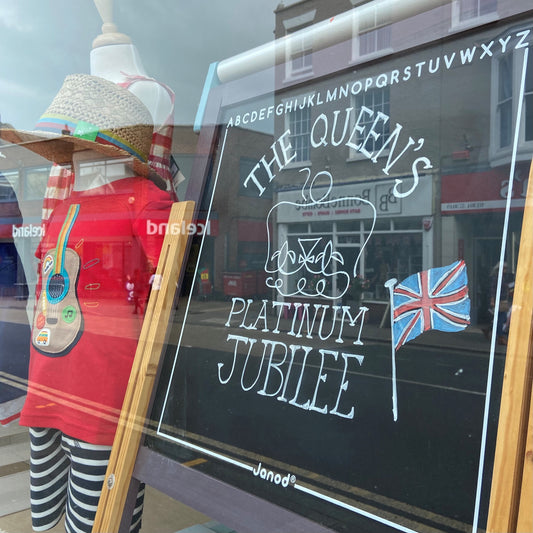 manequin wearing red white and blue outfit and blackboard featuring a platinum jubilee logo in a shop window